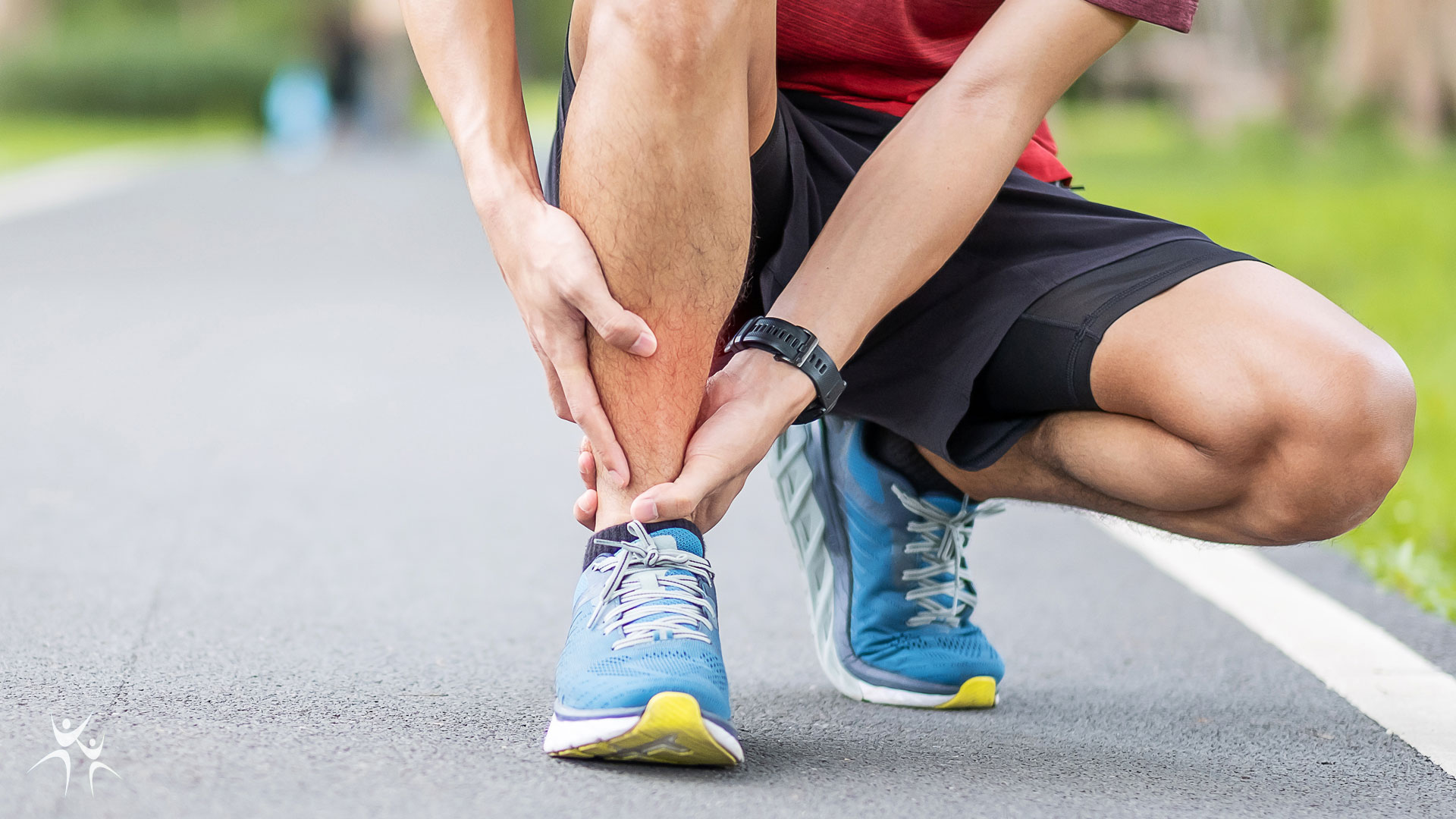 Person crouched down holding ankle in pain from a running injury