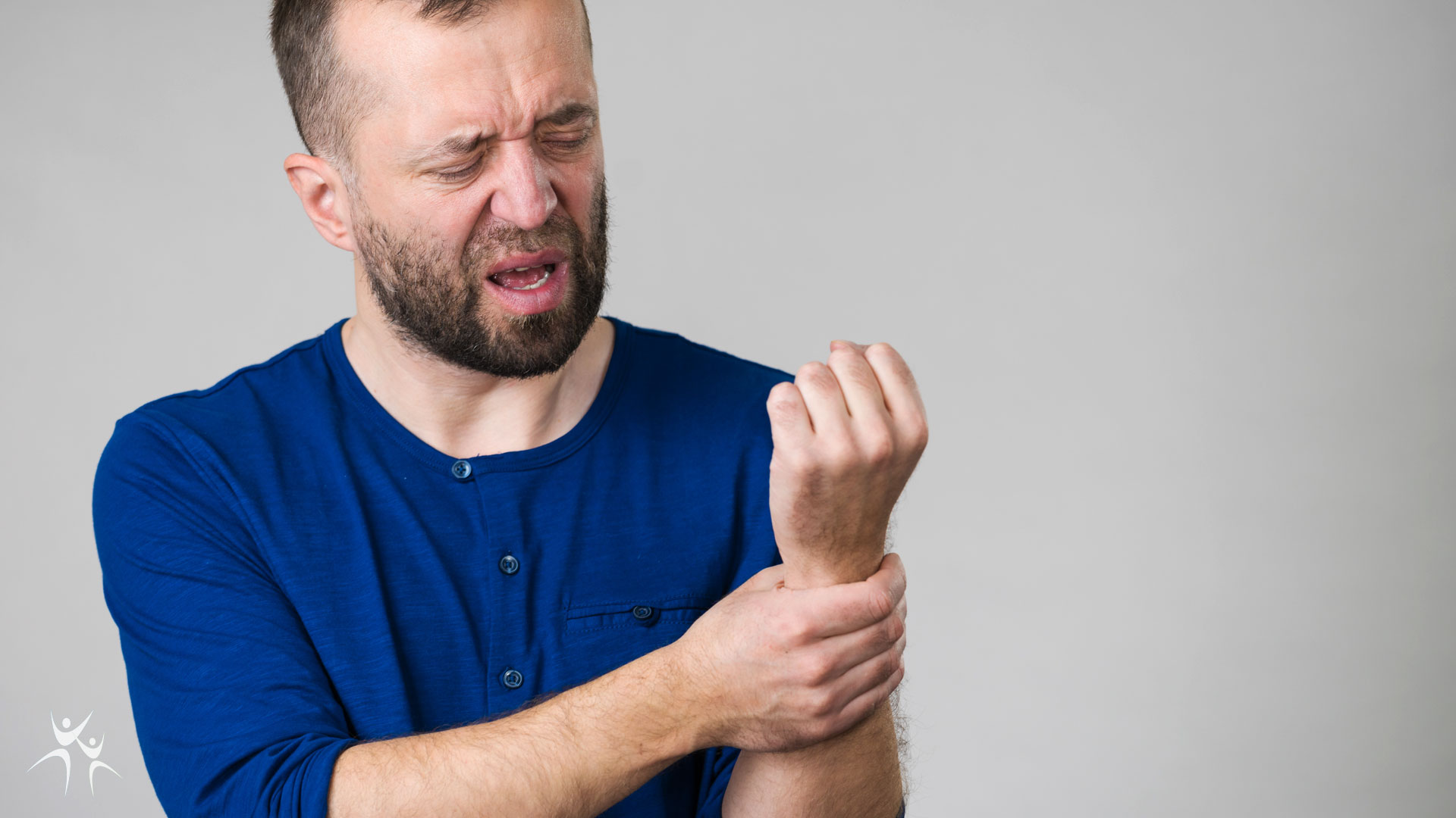 Middle aged man holding wrist to soothe pain