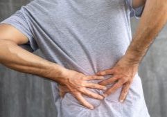 man holding his back with both hands to support pain