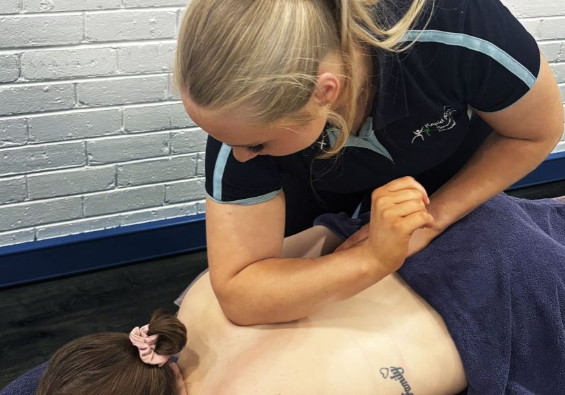 Tara Jenner applying remedial massage techniques to a clients upper back