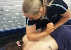 Tara Jenner applying remedial massage techniques to a clients upper back