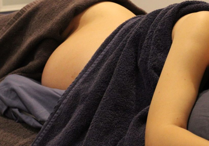 woman laying on side for pregnancy massage at Rapid Recovery Clinic in Healesville